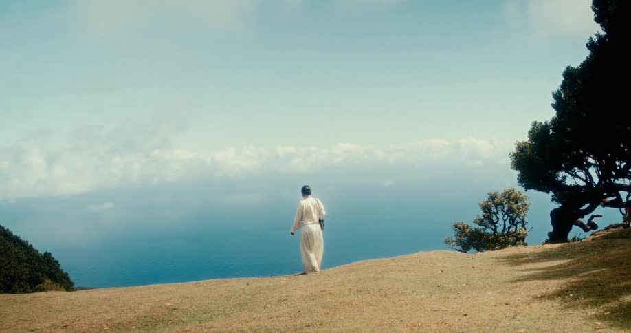A footage of a lady walking on the grassland