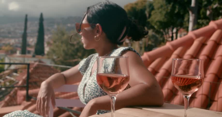 Woman sitting enjoying the view next to the table of two drinks