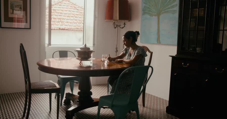Woman sitting at a round wooden table writing