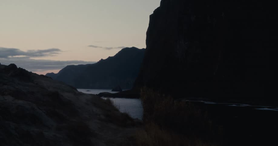 Scenery at dawn with silhouettes of mountains and a calm lake