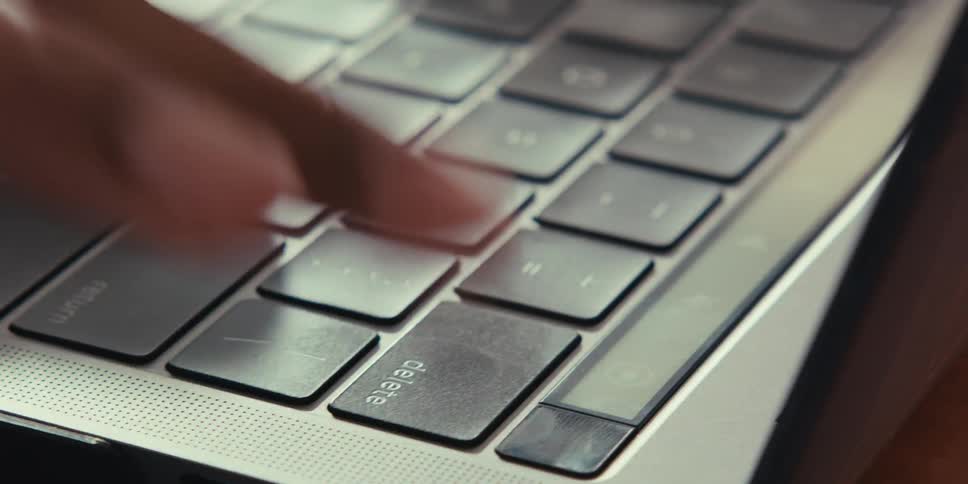 A close up of a finger pressing repeatedly the delete key on a laptop keyboard