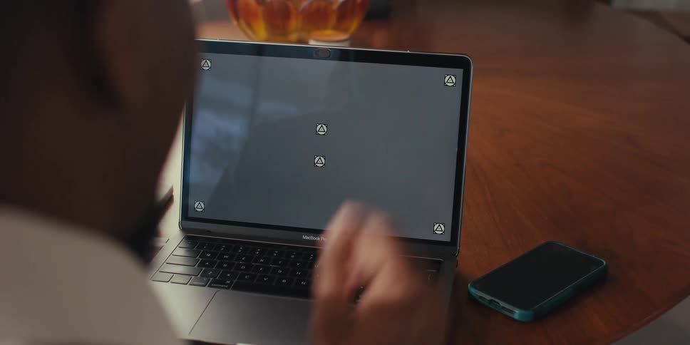 Hand waving at a laptop screen