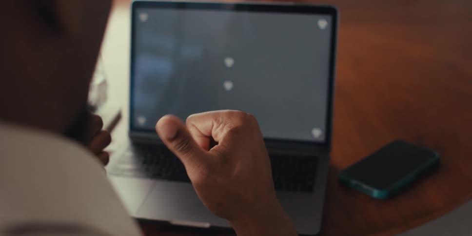 Man gesturing in front of a laptop