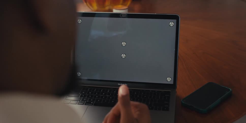 Hands of a person making gestures in front of a laptop