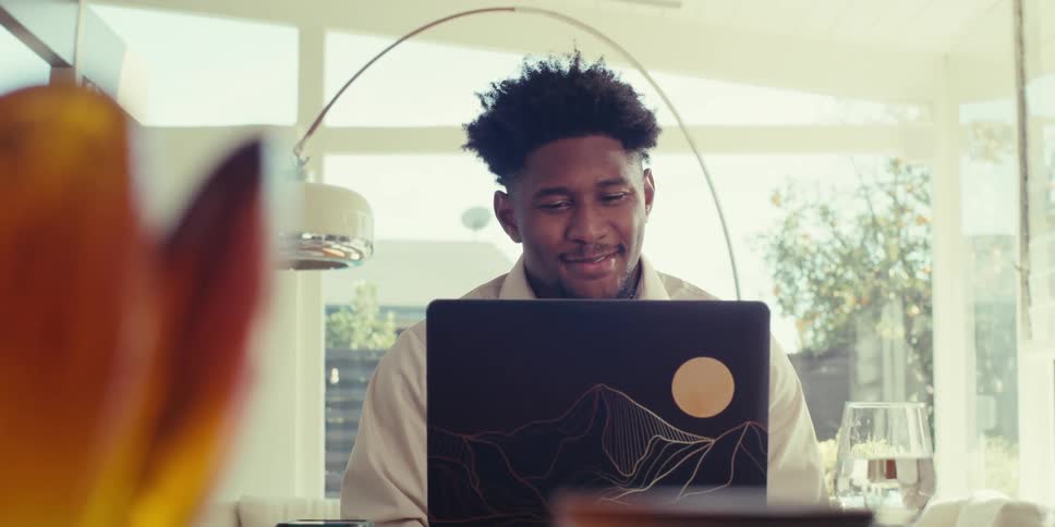 Man sitting at a table in front of a laptop