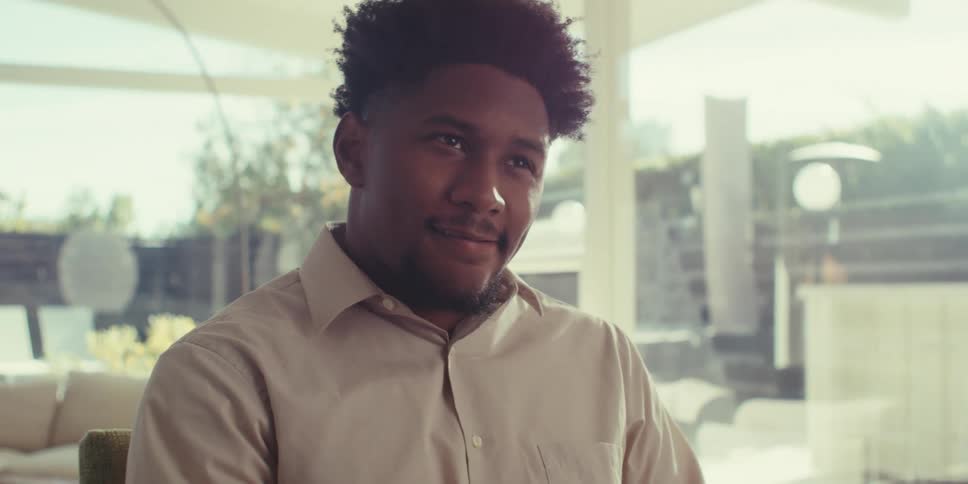 Happy thoughtful man interacting in front of a laptop