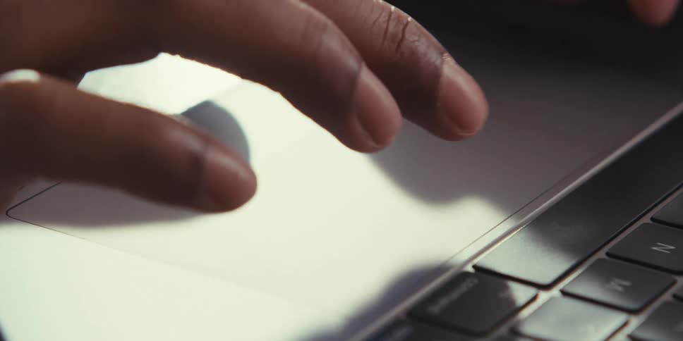 Person uses a touch pad to interact with a laptop computer