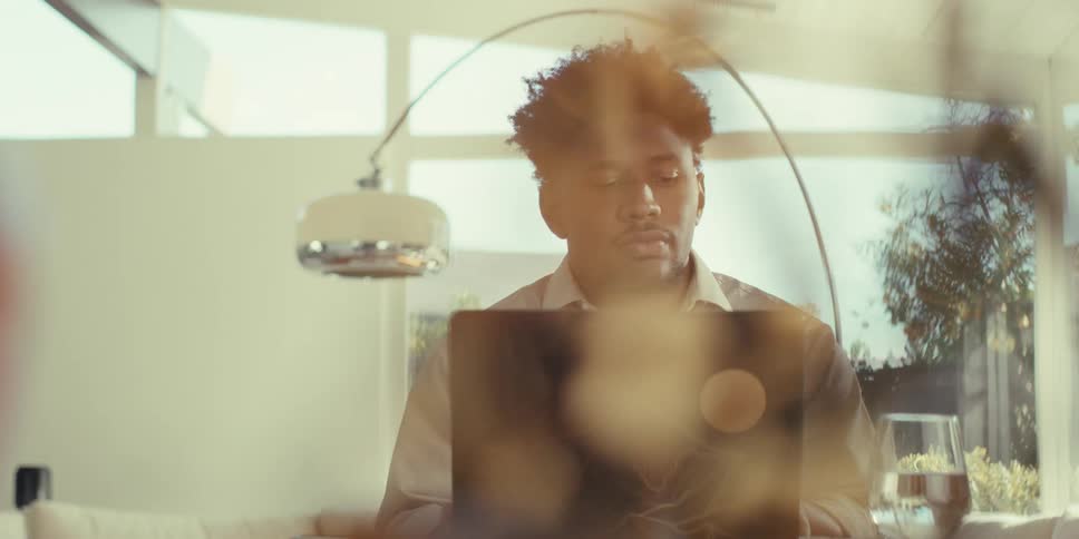 Man sitting in a room in front of a laptop