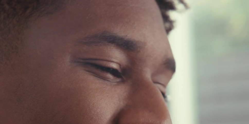 A close up of the eyes of a young person on a sunny room