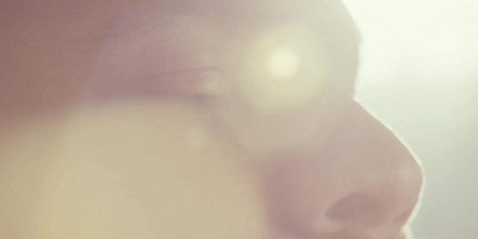 A closeup of a persons face with soft warm lighting creating a dreamy and ethereal atmosphere