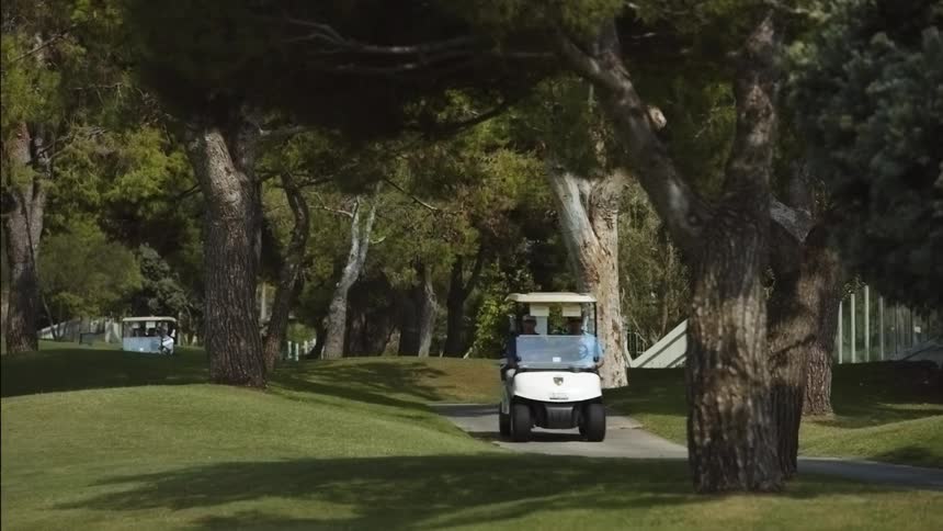 Golf carts travel through a grassy area