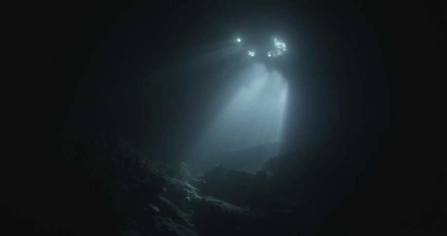 Rays of light shining through an opening in an underwater cave like area