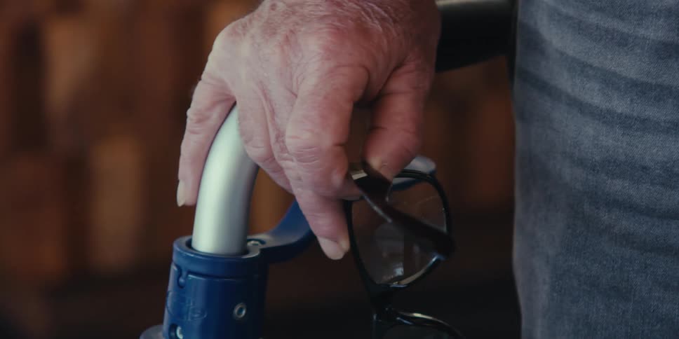 Close up of an elderly persons hand holding glasses