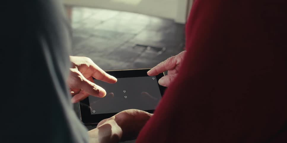 Hands of two people interacting with a tablet