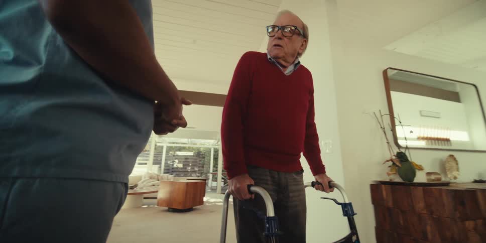 Elderly man and a nurse both standing and talking