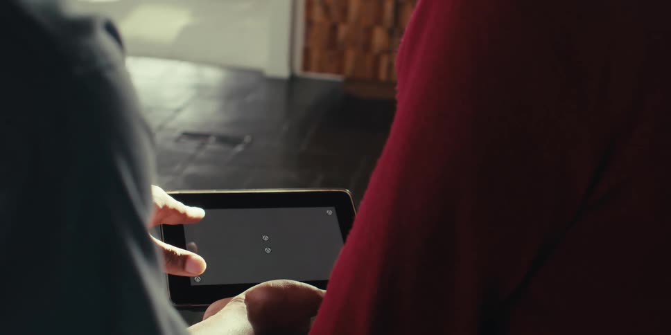 Two people interacting with a small tablet
