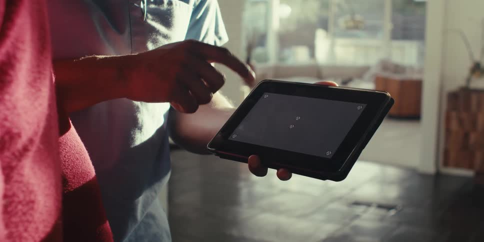 Person holding a tablet and pointing at the screen