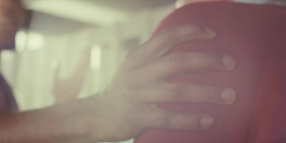 A man is talking with someone and puts his hand on his shoulder