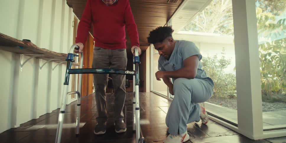 Nurse adjusting a walker for an elderly man