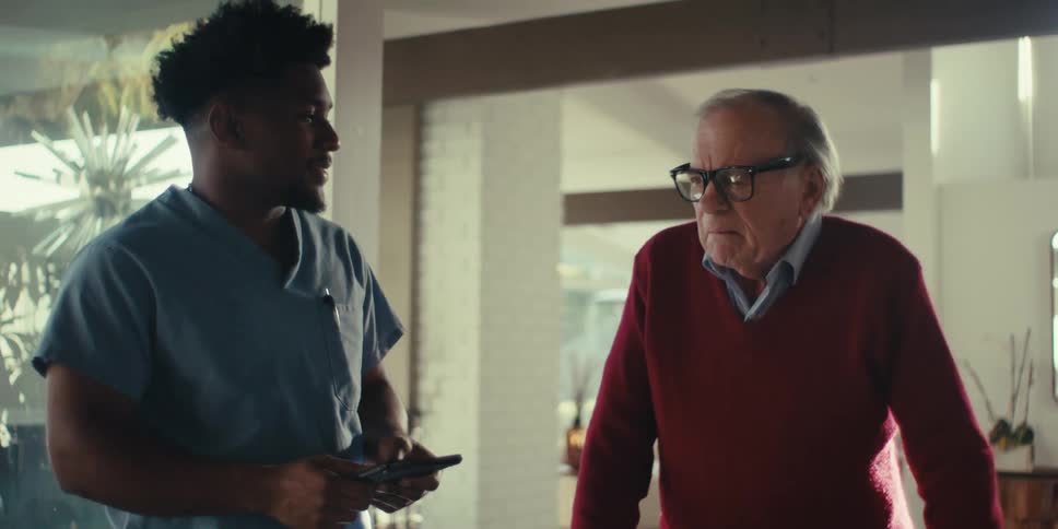 Adult nurse assisting an elderly man to walk