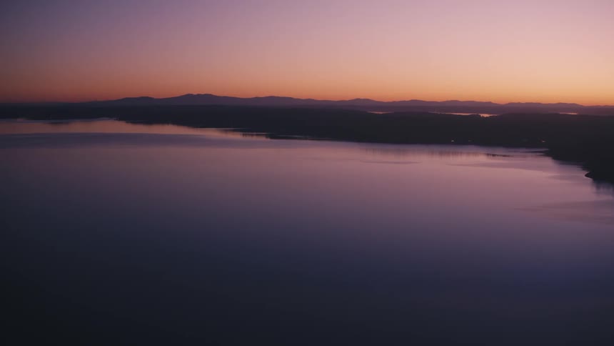 Aerial view of a sea reflecting the purple and orange sky