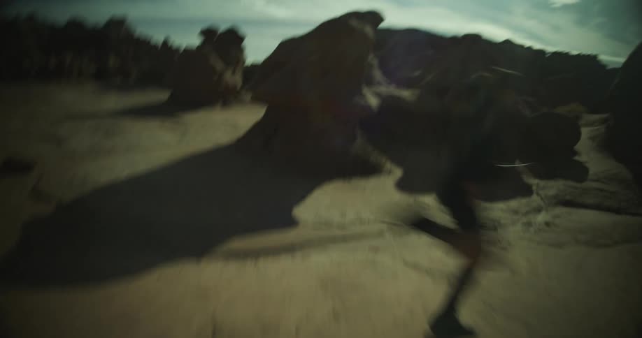 Woman runs between rock formations on a cloudy day