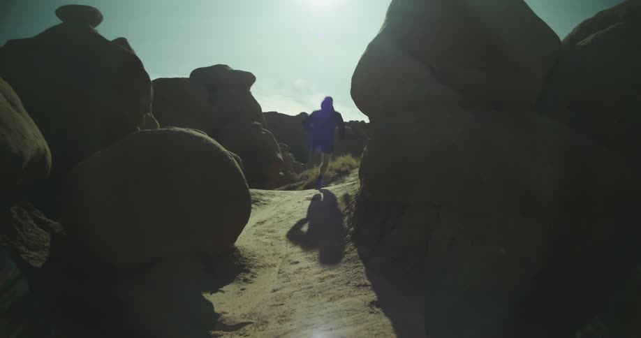 Man runs between rock formations carved by time