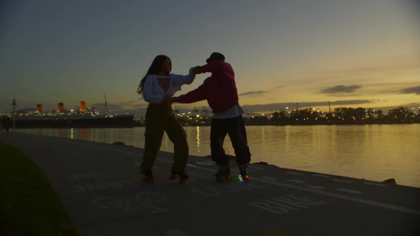 Two people dancing hand in hand with roller skates