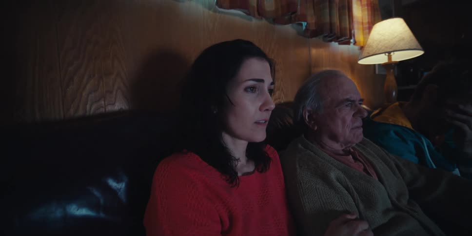 Three people sitting on a couch in the living room watching together