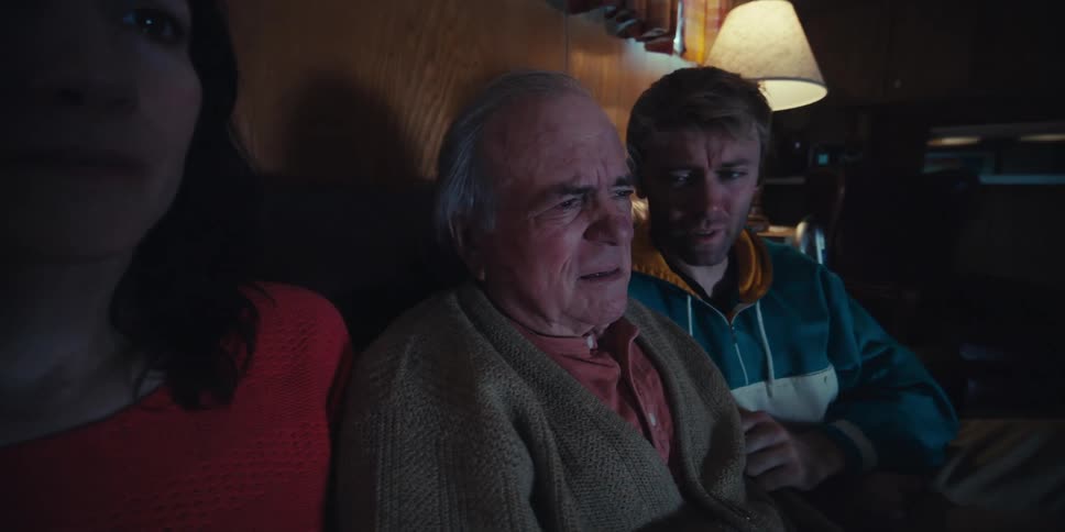 A man is crying as he watches the television