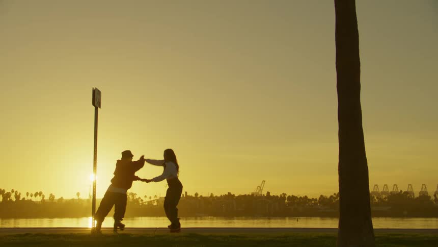 A man and woman are dancing together on roller skates
