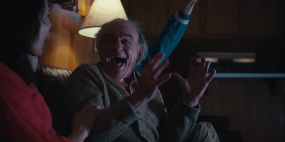 Friends and family celebrate while watching a sporting event at home at night