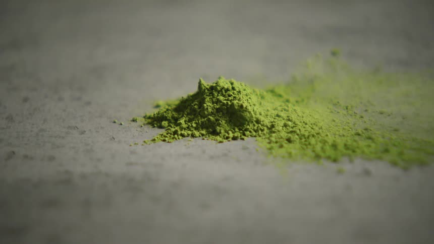 A closeup shot of vibrant green matcha powder shows its fine texture