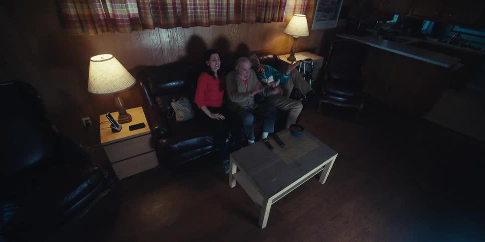 People laugh and throw their arms up at the television