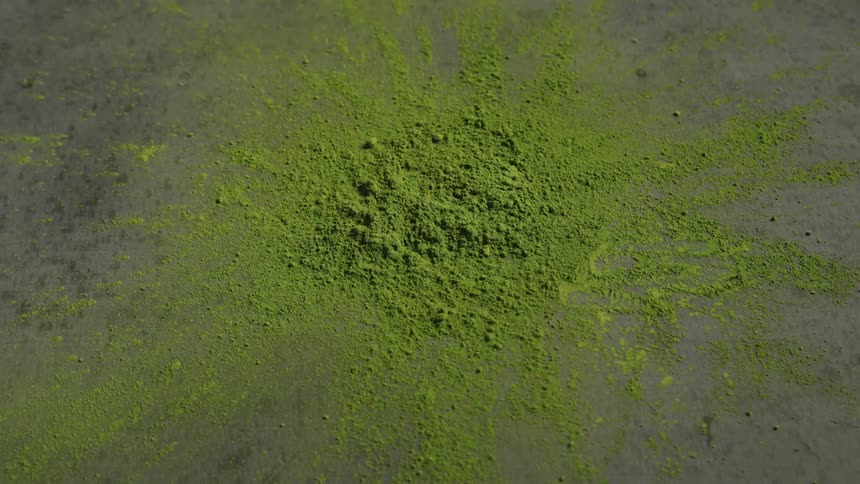 A closeup shot of vibrant green matcha powder shows its fine texture