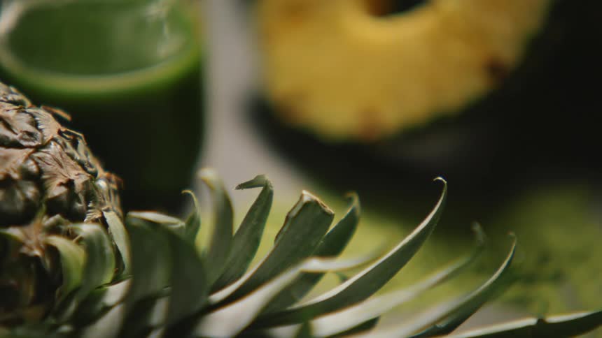 Cut fruit in a glass with green juice in the background