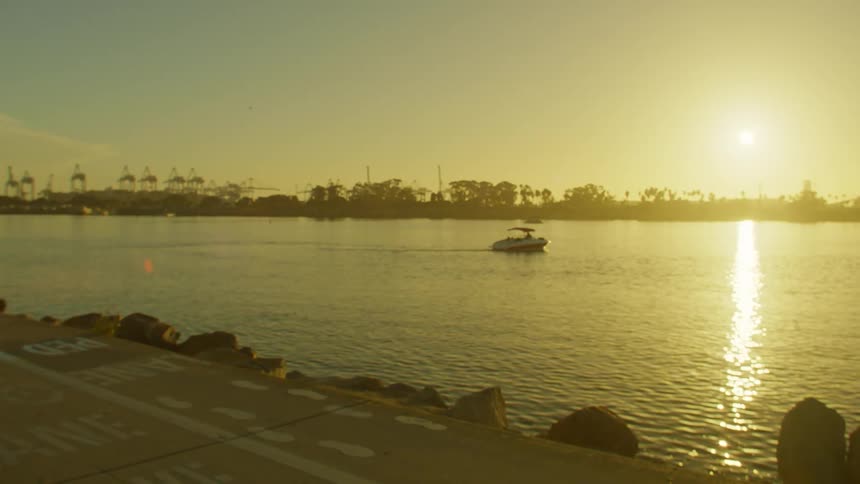 Landscape with the sun on the horizon on a boat floating in calm waters