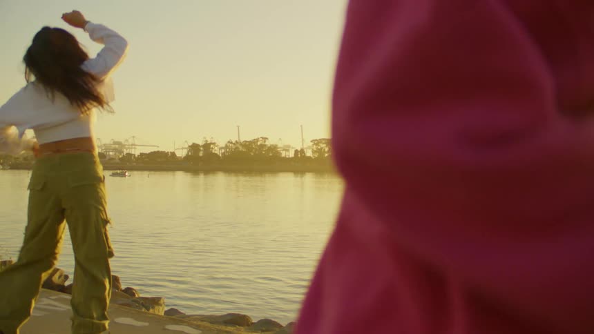 Woman dancing on roller skates by a lake