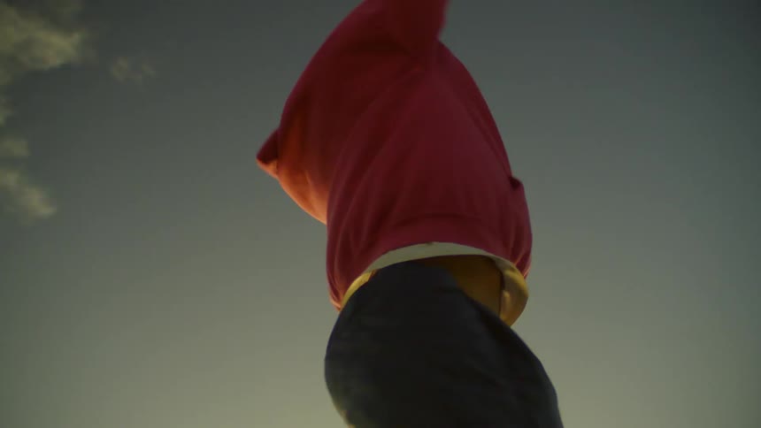 A man spins with his hands up on roller skates