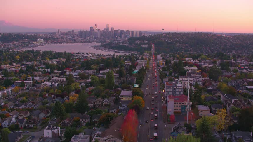 Aerial view of a highway with vehicle traffic that passes through the middle of an urban neighborhood and gives access to a metropolis