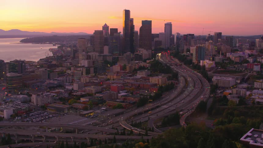 Aerial view of a modern metropolis surrounded by the sea and seen in a purplehued dusk sky