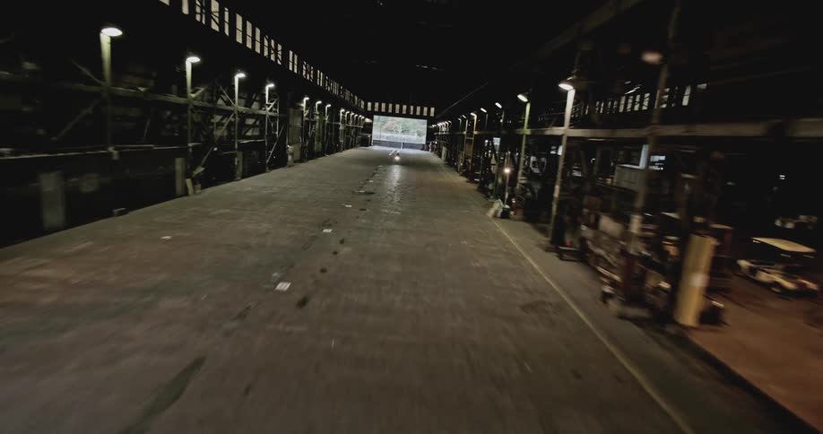 Person on a motorcycle passing inside a warehouse
