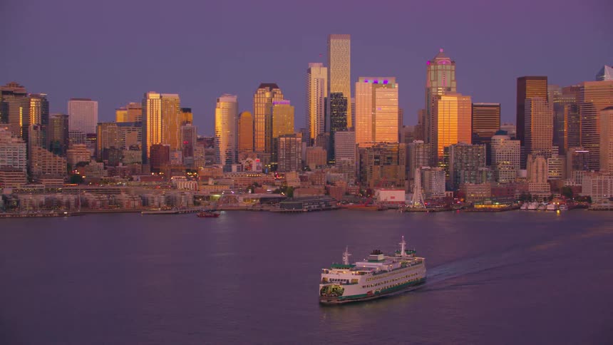 Aerial view of a boat sailing on the sea and a metropolis with modern skyscrapers in the background