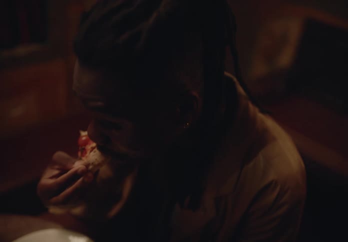Man sitting eating a slice of pizza
