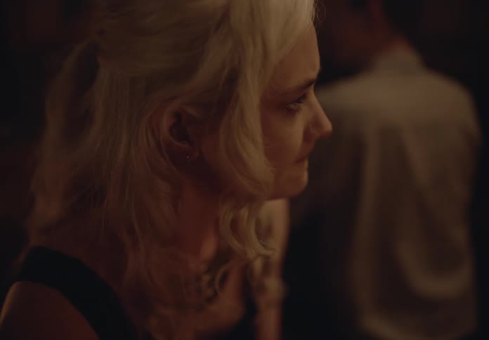 Side portrait of a blonde woman in a pub having a drink