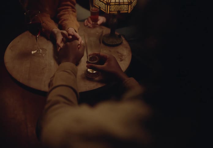 A clip of people having a dink on the table and holding hands