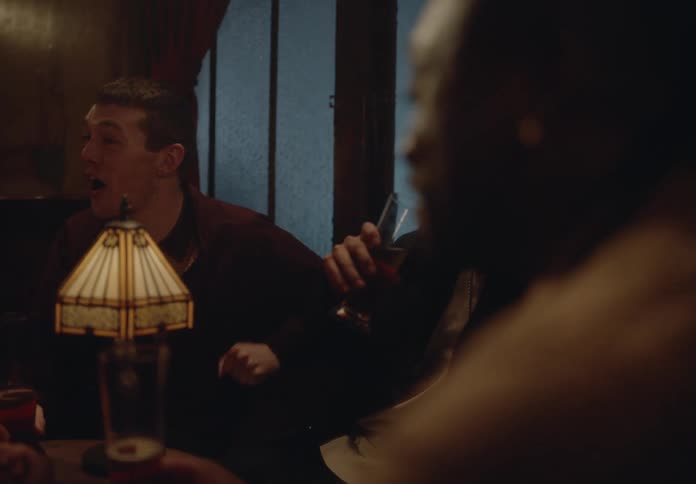 Man and woman holding hands in a bar talking to other friends