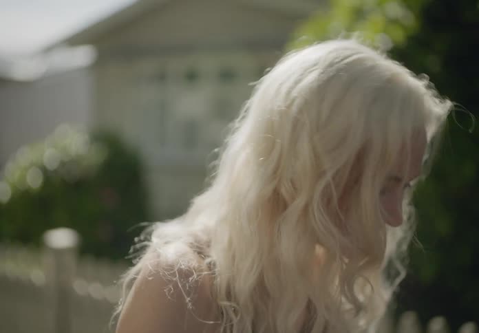Portrait of a blonde woman walking outdoors while happily chatting