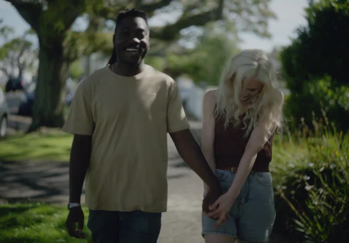 Happy couple holding hands and walking together on the sidewalk in an urban neighborhood