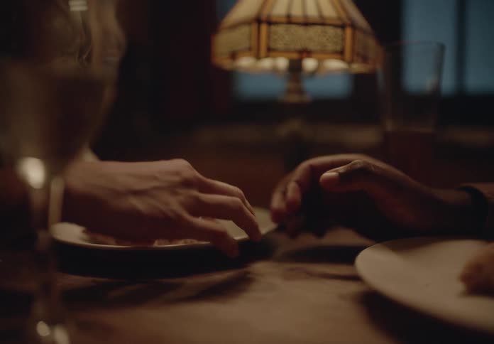 Two people holding hands on a table in a restaurant